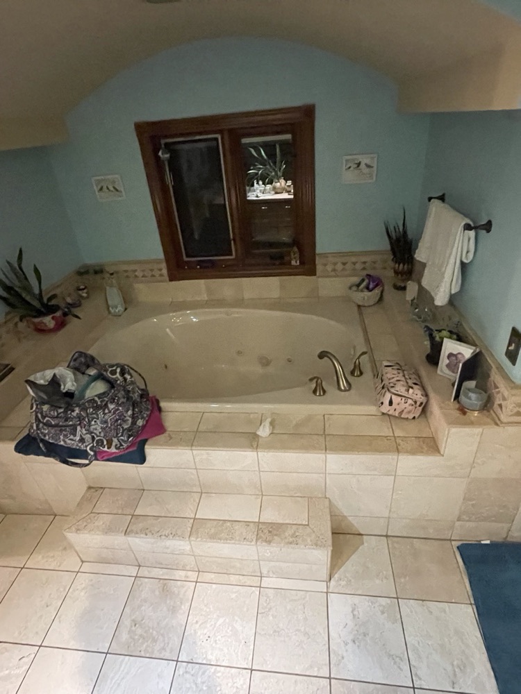 Before: dated garden tub with a cream tile deck