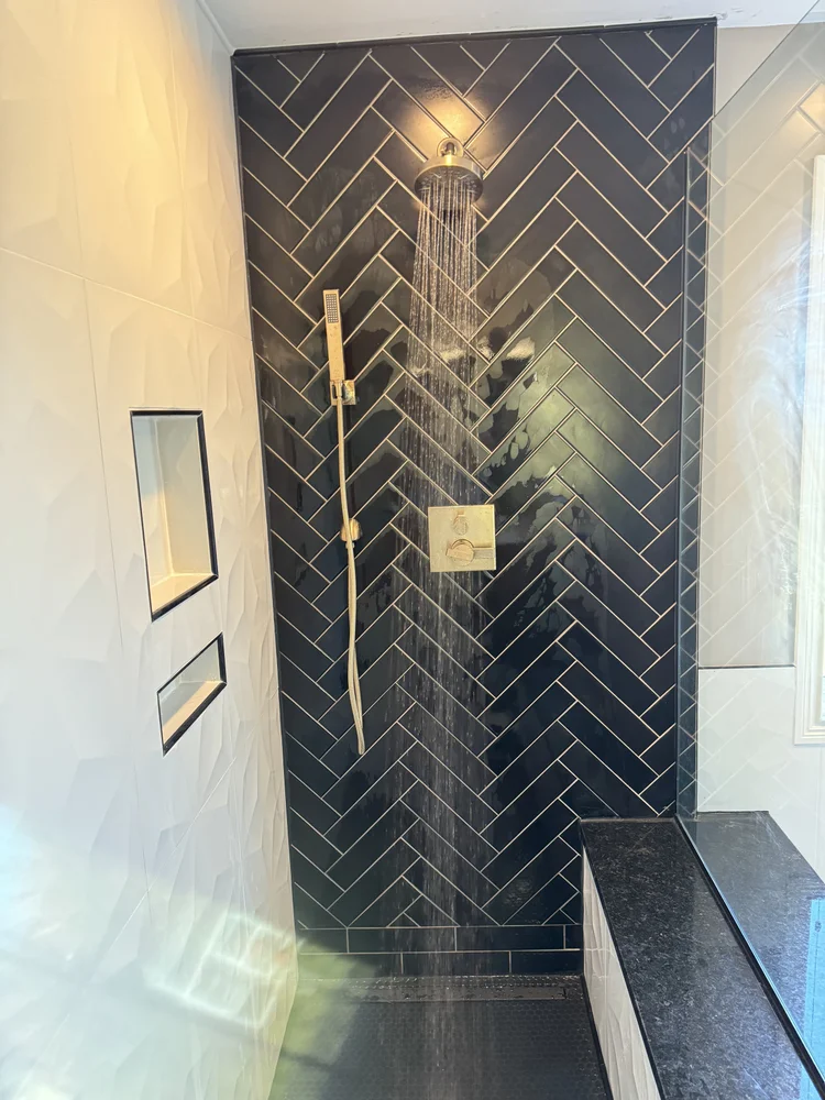 Custom tile walk-in shower with herringbone tile and bench