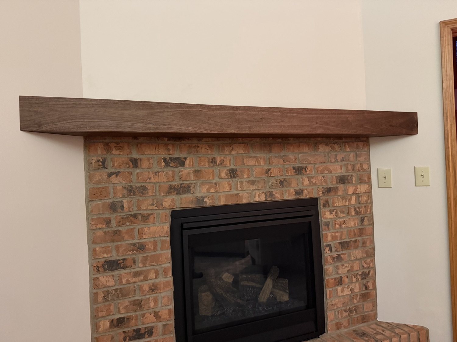 Handmade walnut mantel on a rebuilt brick fireplace in Centerville, OH