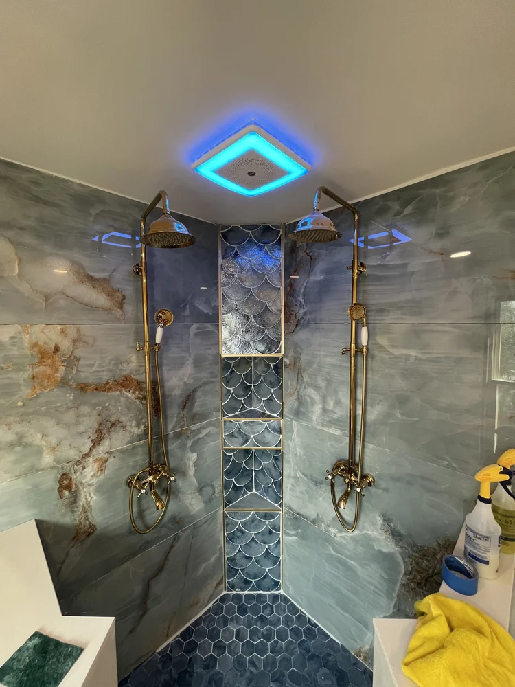 Marble shower with blue fish-scale tile